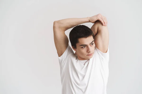 Confident young sportsman doing stretching exercises — Stock Photo, Image