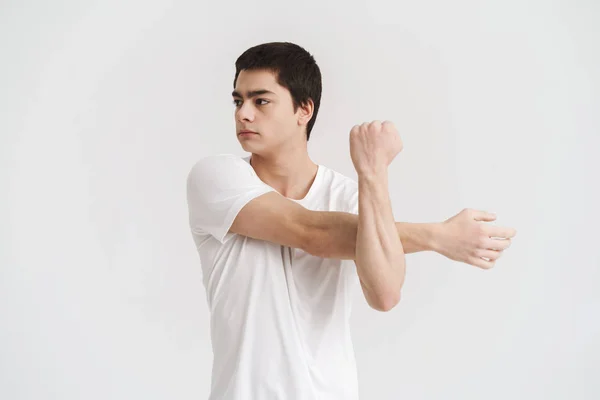 Zelfverzekerde jonge sportman doet Stretching oefeningen — Stockfoto