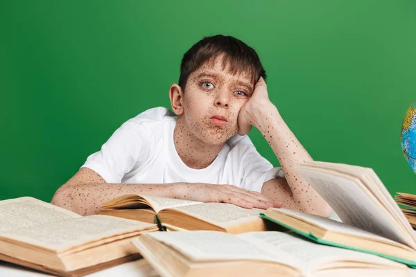 Menino bonito com sardas estudando com pilha de livros — Fotografia de Stock