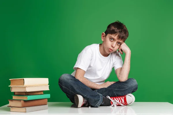 Netter kleiner Junge mit Sommersprossen, der mit einem Stapel Bücher lernt — Stockfoto