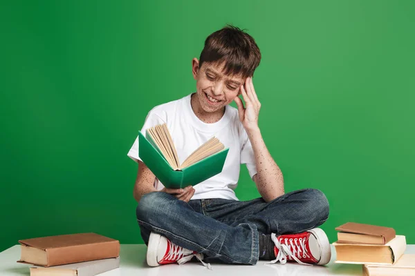 Schattige kleine jongen met sproeten studeren met stapel boeken — Stockfoto