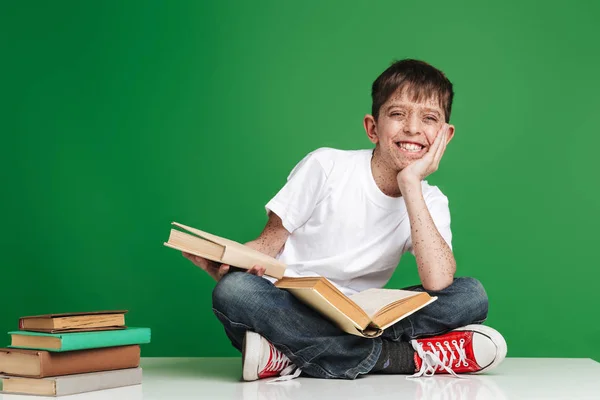 Schattige kleine jongen met sproeten studeren met stapel boeken — Stockfoto