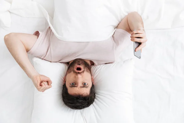 Vista superior de um jovem bonito deitado na cama — Fotografia de Stock