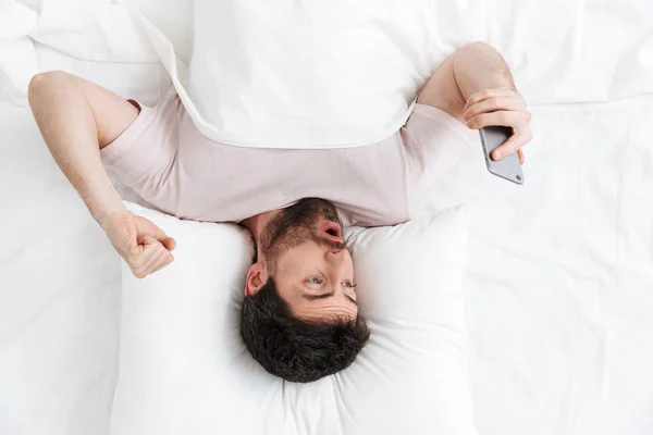 Top view of a handsome young man laying in bed — Stock Photo, Image