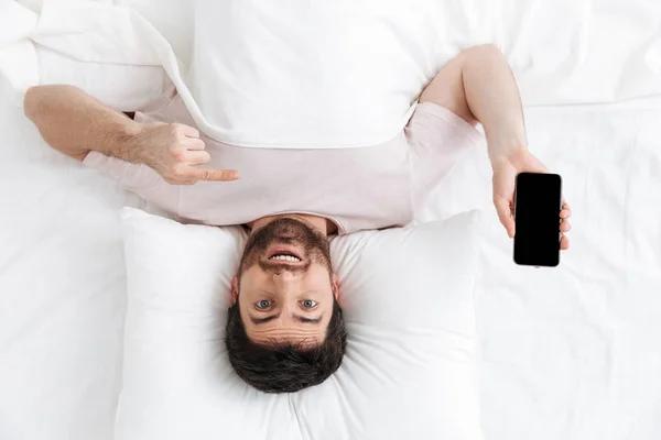 Vue du dessus d'un beau jeune homme couché au lit — Photo