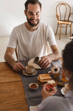 Neşeli esmer çift in masada birlikte yemek görüntüsü h