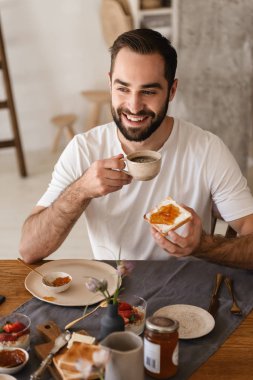 Yakışıklı esmer adam portresi 20s akıllı telefon kullanarak iken hav