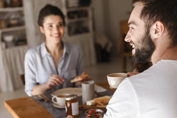 Imagen de pareja morena positiva comiendo juntos en la mesa mientras — Foto de Stock