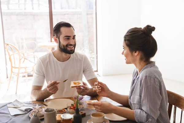 Bild von zufriedenen Brünetten beim gemeinsamen Frühstück — Stockfoto