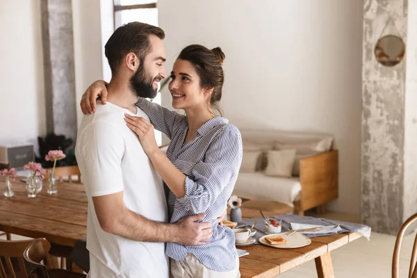 Photo of excited brunette couple in love smiling while hugging t — Stock Photo, Image