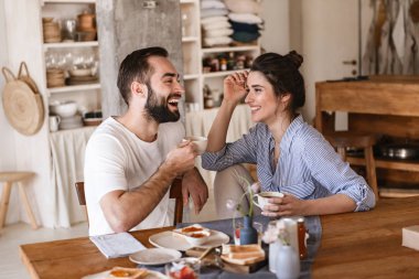 Modern esmer çift birlikte kahvaltı ederken Görüntü 