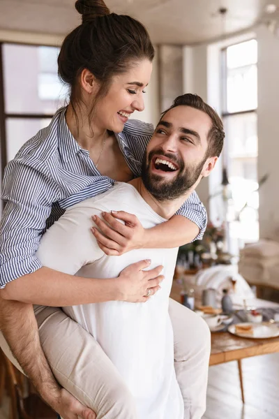 Foto de pareja morena juguetona enamorada sonriendo mientras abraza t — Foto de Stock