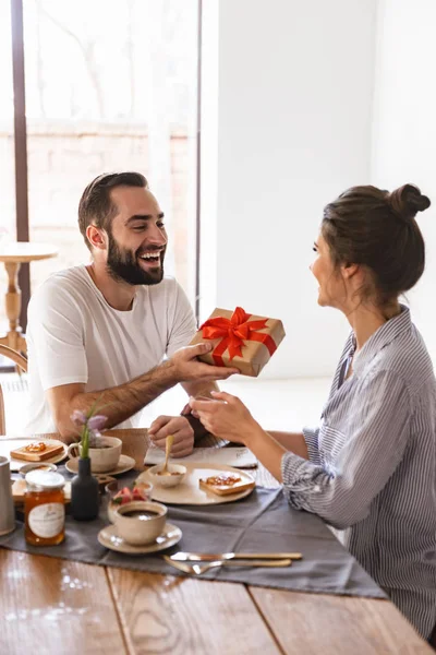 Foto de pareja joven morena desayunando en apartamento whi — Foto de Stock