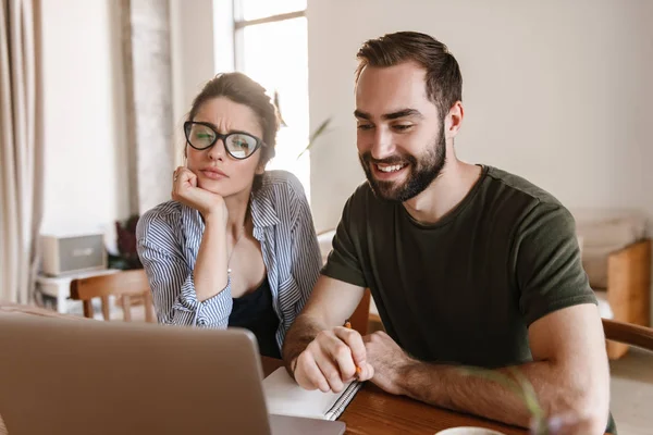 Imagem de casal morena moderna trabalhando no laptop juntos enquanto — Fotografia de Stock