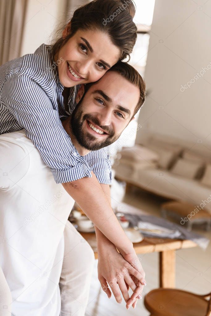 Photo of attractive brunette couple in love smiling while huggin