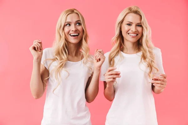 Usmívající se dvojčata, která si užívala triček a dívá se jinam — Stock fotografie