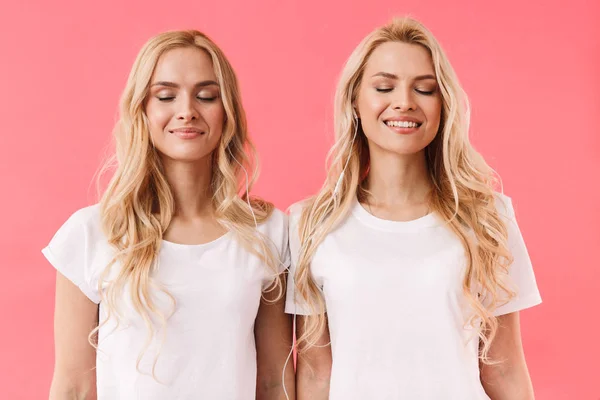 Blij blonde tweeling dragen in t-shirts poseren met gesloten ogen — Stockfoto