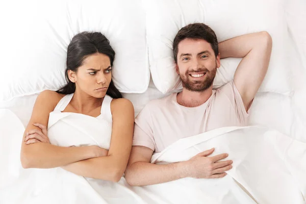 Disputa descontente jovem casal amoroso encontra-se na cama sob cobertor . — Fotografia de Stock