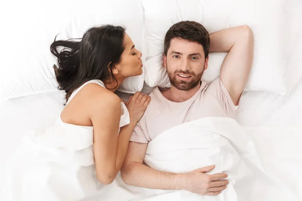 Νεαρό ζευγάρι που αγαπά βρίσκεται στο κρεβάτι με κουβέρτα. — Φωτογραφία Αρχείου