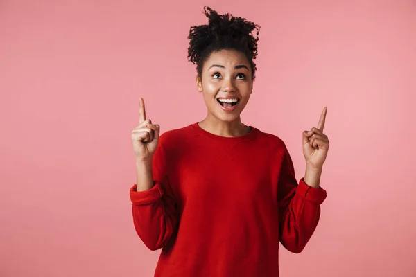 Joven emocionado mujer africana emocional feliz posando aislado sobre fondo de pared rosa señalando . —  Fotos de Stock