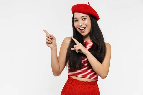 Bonita sorrindo jovem bonita asiática mulher posando isolado sobre branco parede fundo apontando . — Fotografia de Stock