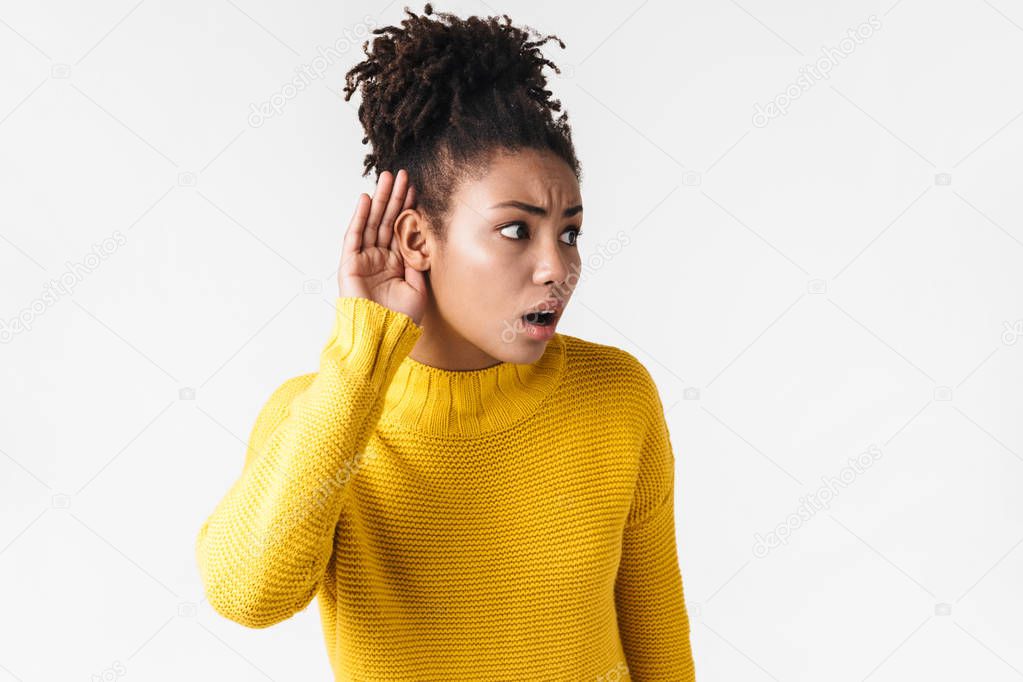 Young african emotional woman posing isolated over white wall background try to hear you.