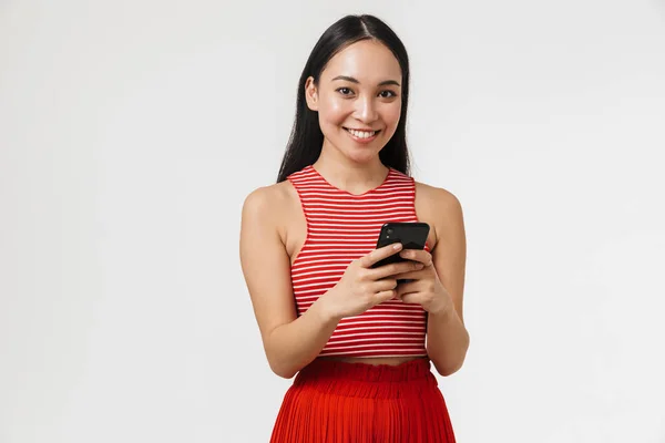 Bonita jovem bonita asiático feliz mulher posando isolado sobre branco parede fundo usando celular . — Fotografia de Stock