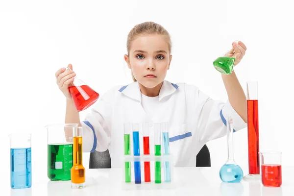 Retrato de pequeña alumna en bata de laboratorio blanca haciendo ch —  Fotos de Stock