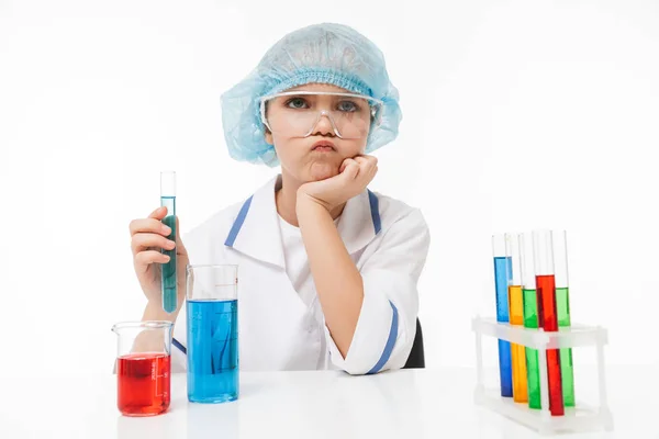Porträtt av fokuserad liten flicka i vitt laboratorium päls gör — Stockfoto
