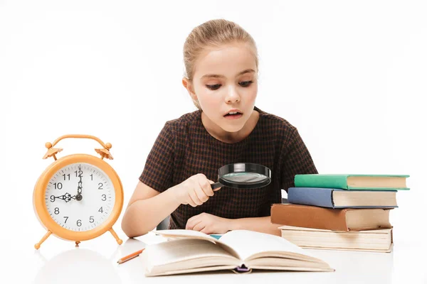 Porträt eines kaukasischen Schulmädchens mit großem Wecker auf dem Schreibtisch — Stockfoto