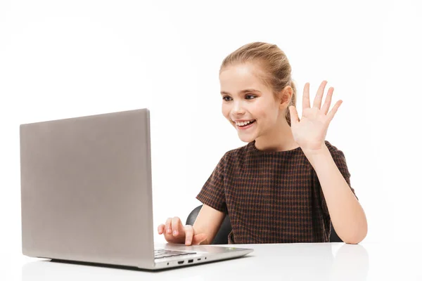 Portrait of cheerful school girl rejoicing and using silver lapt — Stock Photo, Image