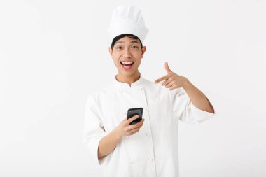 Image of young chinese chief man in white cook uniform and chef'