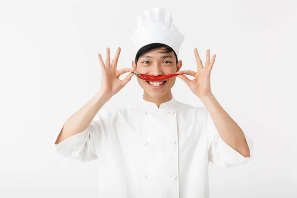 Imagem de asiático divertido chefe homem em branco cozinheiro uniforme com vermelho — Fotografia de Stock