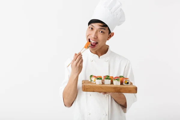 Imagem de homem chefe chinês alegre em branco cozinheiro uniforme holdin — Fotografia de Stock