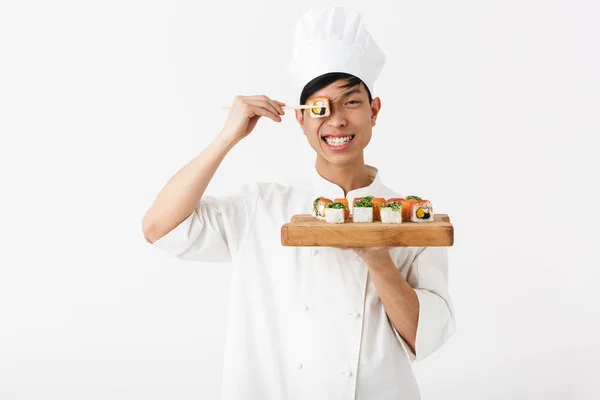 Image of smiling chinese chief man in white cook uniform holding