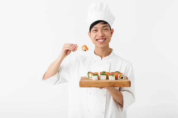 Image of positive chinese chief man in white cook uniform holdin