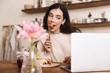 Gülümseyen genç kadın kahvaltı