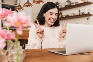 Mutfakta oturan gülümseyen genç kadın