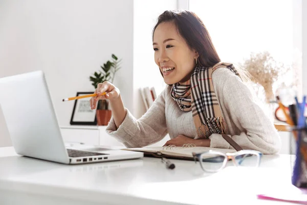 Задоволена азіатська бізнес жінка використовує ноутбук комп'ютер і насолоджується — стокове фото