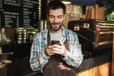 Beyaz barista adam portresi cep telefonu üzerinde stre yazarak