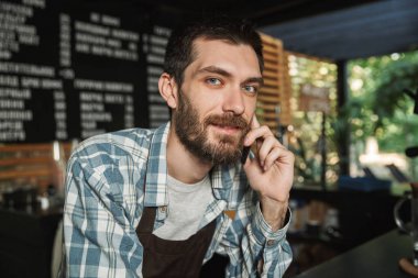 Etkileyici barista adam portresi içinde cep telefonda konuşan Stree