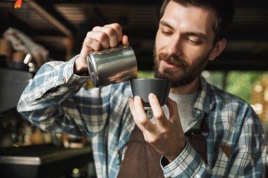 CAF çalışırken esmer barista adam kahve yapma görüntü
