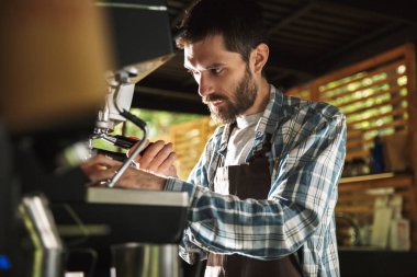 Kafede çalışırken sakallı barista çocuk kahve yapma görüntü