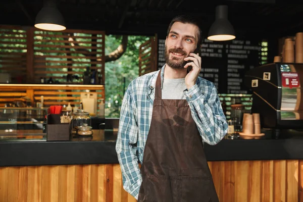 Portrait de barista gai gars parlant sur téléphone portable dans la rue — Photo