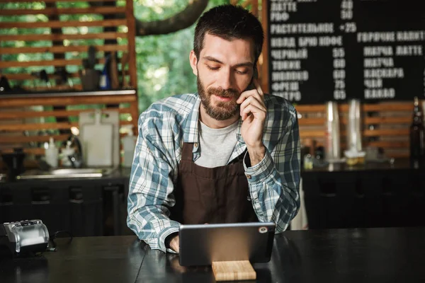 Retrato del hombre alegre barista usando tableta mientras worki —  Fotos de Stock