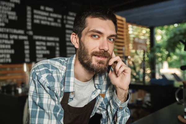 Portrait d'attrayant barista gars parler sur téléphone portable en degrés — Photo