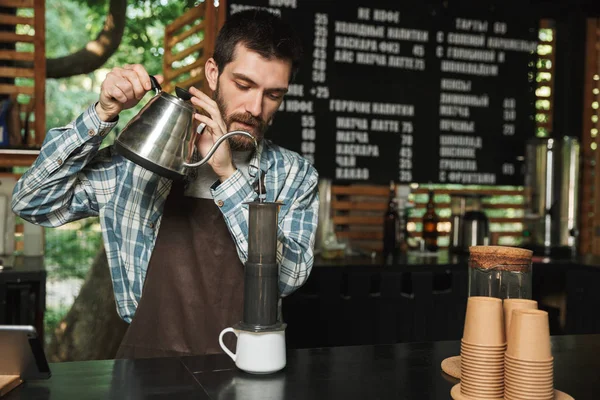 Retrato de barista caucásico haciendo café mientras trabajaba en —  Fotos de Stock