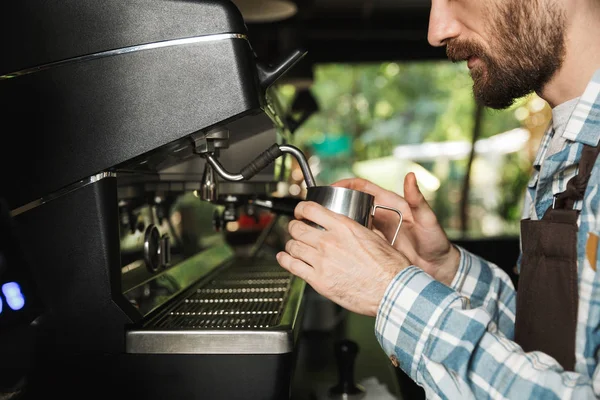 Imagen del hombre barista concentrado haciendo café mientras trabaja en —  Fotos de Stock