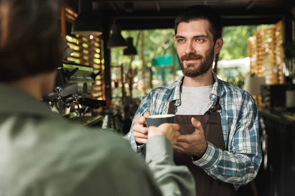 Retrato de homem barista não raspado sorrindo enquanto trabalhava na rua — Fotografia de Stock