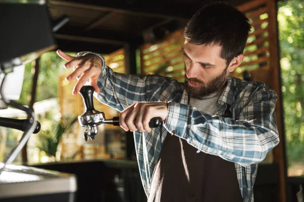Obrázek vážného baristy, který dělá kávu při práci v kavárně — Stock fotografie